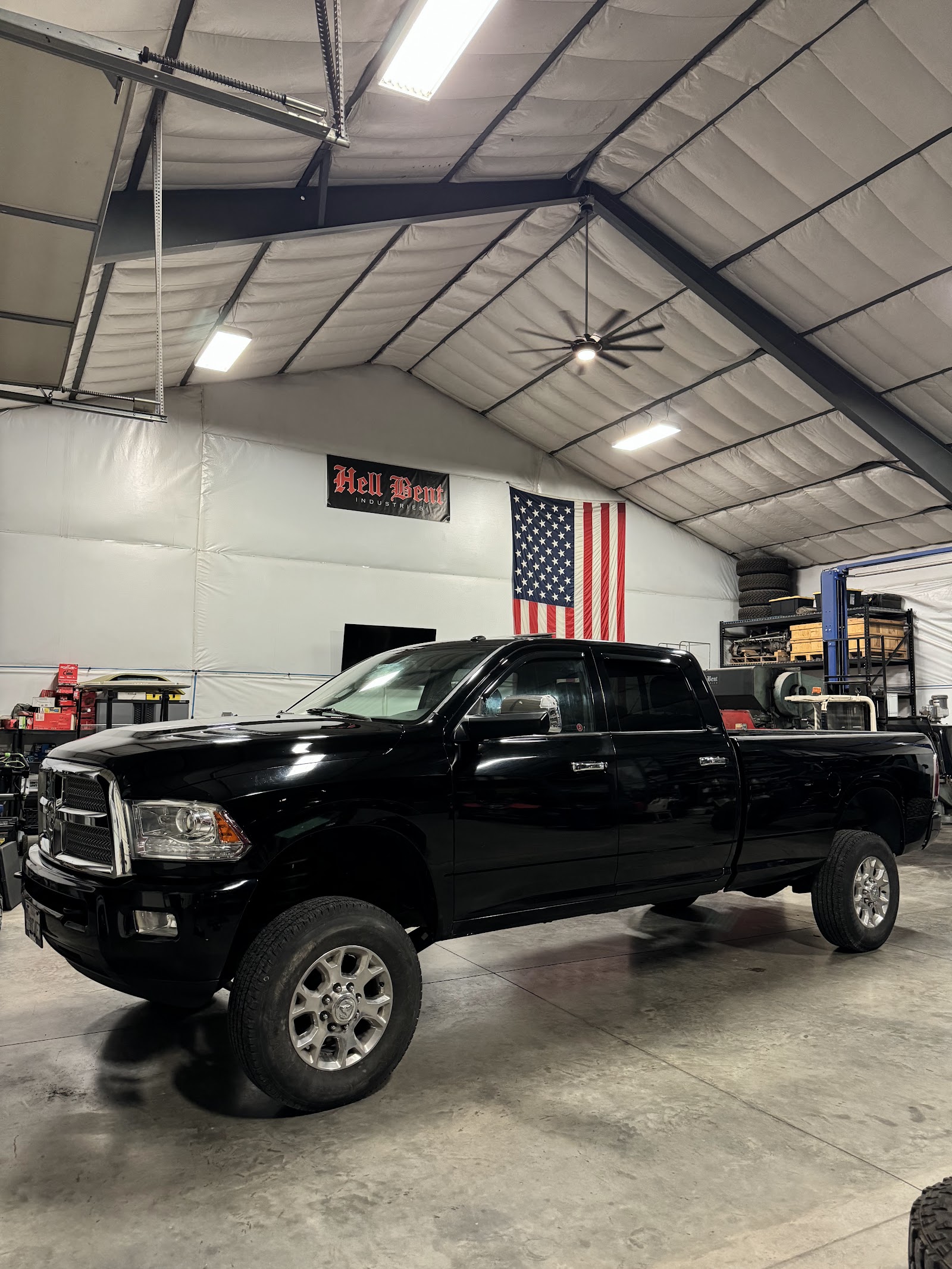 Black Ram pickup truck with tinted windows in a shop beside an American flag