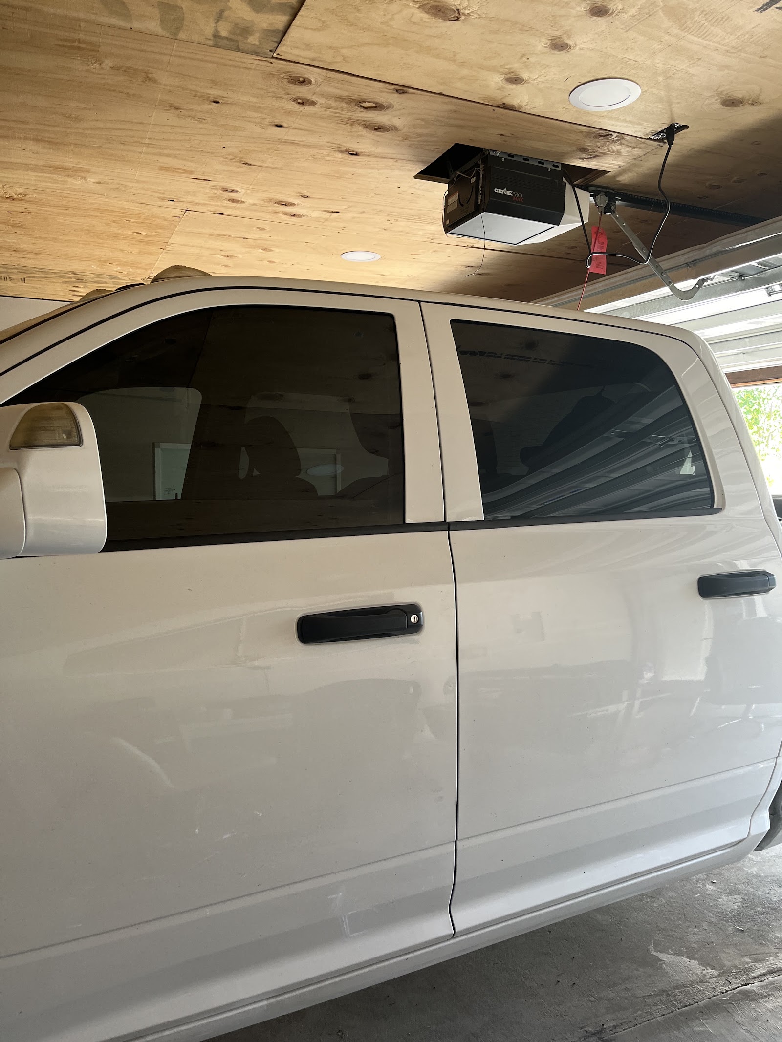 White pickup truck with tinted side windows in a garage