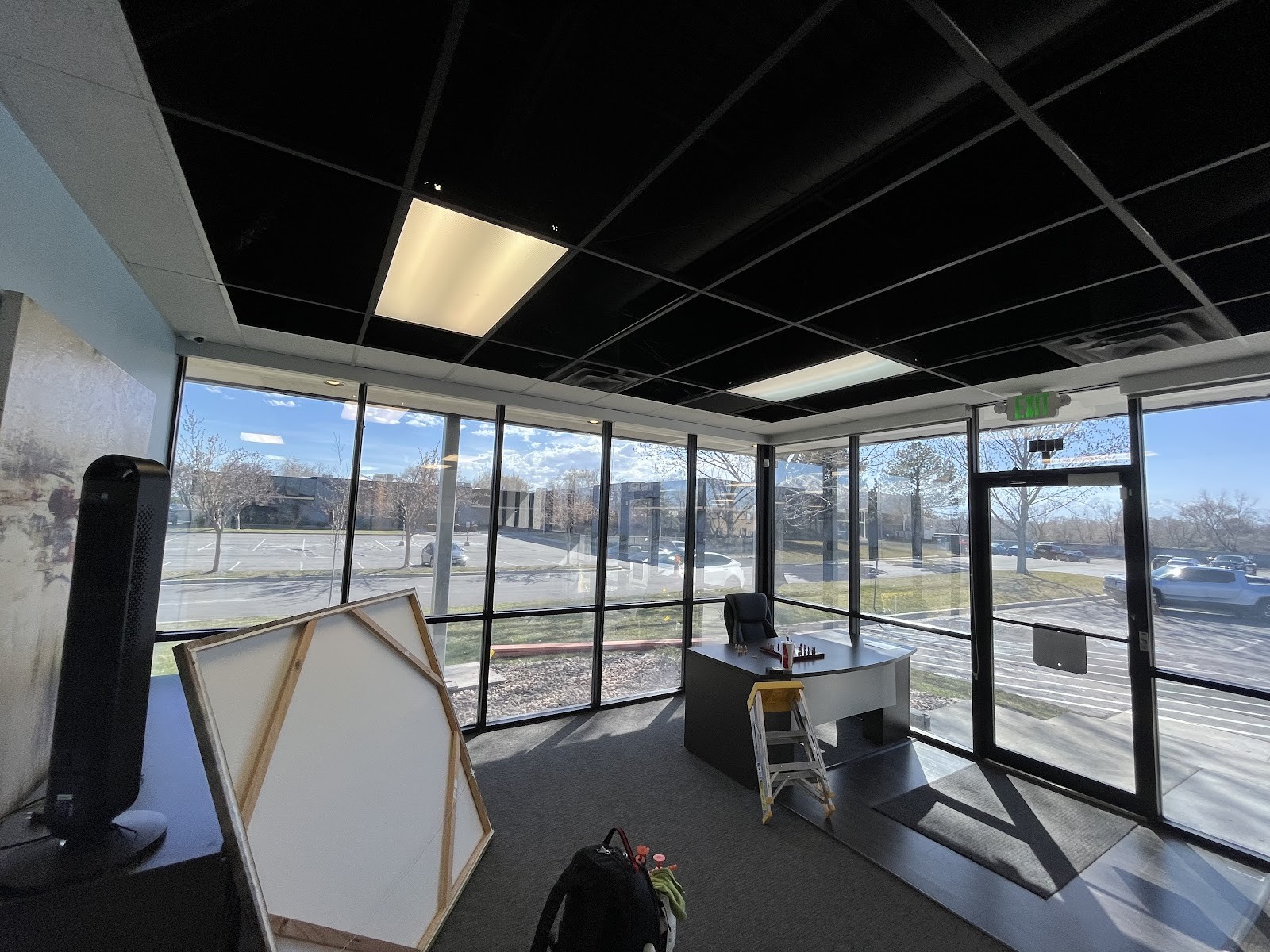Commercial office with floor-to-ceiling tinted windows and a parking lot view
